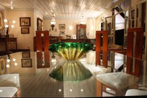 un jarrón de cristal verde sentado en una mesa de cristal en Pousada Beco Do Bispo en São João del Rei