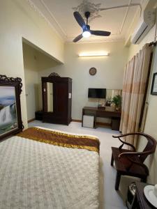 una camera con letto e ventilatore a soffitto di Thang Long Hotel a Hanoi