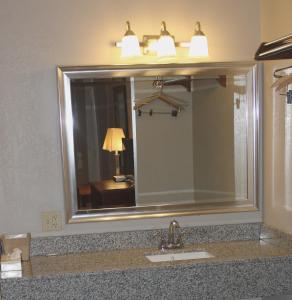 een badkamer met een wastafel en een grote spiegel bij Interstate Motel in Rensselaer