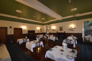 a dining room with white tables and chairs at Creag Mhor Lodge in Onich
