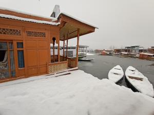 a building with two boats parked next to the water at Houseboat New Suzan in Srinagar