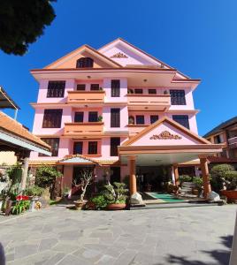 a pink building with a courtyard in front of it at Villa Pink House in Da Lat