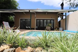 a house with a swimming pool in front of a house at Memories Made Cottage in Kampersrus AH