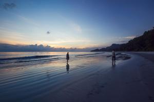 Dos personas caminando por la playa al atardecer en Sea Shell Resort & Spa, Havelock, en Isla Havelock