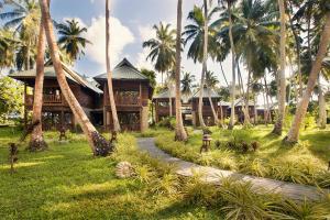 a resort with palm trees in front of a building at Sea Shell Resort & Spa, Havelock in Havelock Island