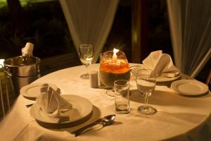 a table with a candle and plates and wine glasses at Sea Shell Resort & Spa, Havelock in Havelock Island
