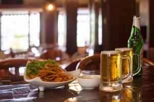 a table with a bowl of food and a bottle of beer at Sea Shell Resort & Spa, Havelock in Havelock Island