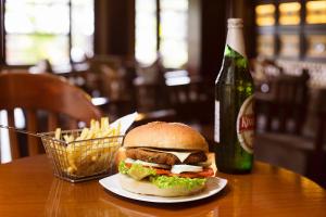 a sandwich and fries on a table with a bottle of beer at Sea Shell Resort & Spa, Havelock in Havelock Island