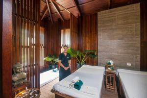 a woman standing in a room with a bed at Sea Shell Resort & Spa, Havelock in Havelock Island