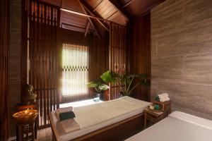 a bedroom with a bed and a window with a plant at Sea Shell Resort & Spa, Havelock in Havelock Island