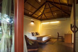 a bedroom with a bed and a chair in a room at Sea Shell Resort & Spa, Havelock in Havelock Island