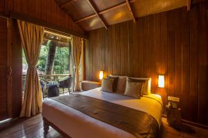 a bedroom with a bed and a large window at Sea Shell Resort & Spa, Havelock in Havelock Island
