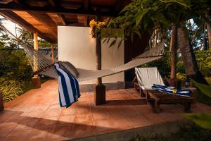 a hammock on a patio with two chairs at Sea Shell Resort & Spa, Havelock in Havelock Island
