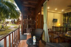 a balcony of a house with a table and chairs at Sea Shell Resort & Spa, Havelock in Havelock Island