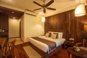 a bedroom with a bed and a table and a ceiling fan at Sea Shell Resort & Spa, Havelock in Havelock Island