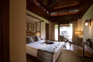 a bedroom with a large bed and a living room at Sea Shell Resort & Spa, Havelock in Havelock Island
