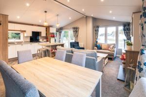 a kitchen and living room with a table and chairs at The Haven Lodge with Hot Tub in York