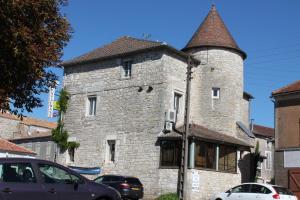 un antico edificio in pietra con una torretta su una strada di Logis Hotels- Auberge de la Tour - Hôtel et restaurant a Sauzet