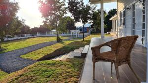 a wicker chair sitting on the porch of a house at Stayokay Sattahip - Flat House in Sattahip