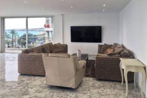 uma sala de estar com 2 sofás e uma televisão de ecrã plano em Promenade des anglais Amazing sea view 140M2 3BR em Nice