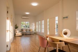 a living room with a wooden table and chairs at Stayokay Sattahip - Flat House in Sattahip