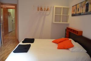 a bedroom with a bed with orange pillows on it at Gaudí Apartment in Barcelona