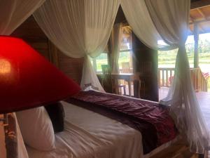1 dormitorio con 1 cama con lámpara roja y ventana en Umadesa Ubud, en Ubud