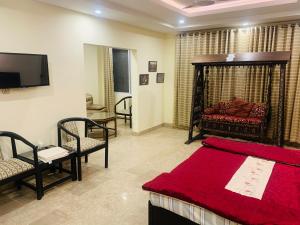 - une chambre avec un lit, une télévision et un canapé dans l'établissement Thikana Hotel, à Muzaffarabad