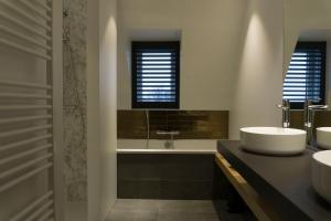 a bathroom with two sinks and a tub and a window at Hotel Central in Roosendaal