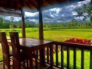 porche con mesa y sillas y vistas al campo en Umadesa Ubud, en Ubud