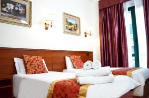 a hotel room with two beds with towels on them at Hotel Geo in Rome