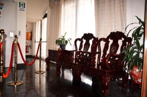a room with chairs and a table with a red ribbon at Hotel Geo in Rome