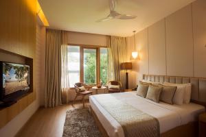 a hotel room with a bed and a television at Sea Shell Port Blair in Port Blair