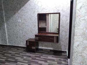 a mirror and a dresser in a room with a wall at Iwaa Alkharj Apartments in Al Kharj