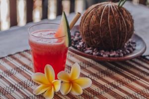 una bebida sentada en una mesa junto a una fruta tropical en Mailaku House en Kerobokan