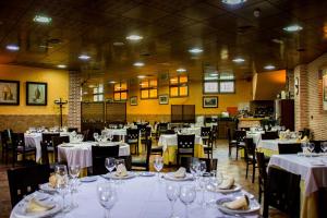 a dining room with tables and chairs with white tablecloths at Hotel Rural El Jardin in Aldea del Fresno