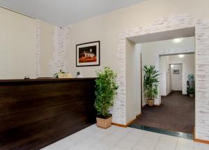 a lobby with two potted plants in a building at Hotel Vizit in Cherepovets