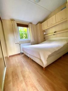 sypialnia z dużym łóżkiem i oknem w obiekcie Vakantiehuis Veluwe Wageningen w mieście Wageningen