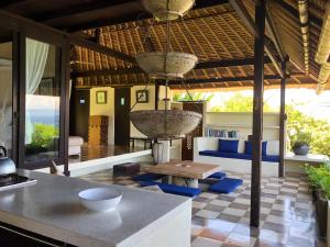 a kitchen and living room with a table and chairs at Bloo Lagoon Eco Village in Padangbai