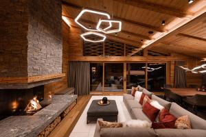 a living room with a couch and a fireplace at Arla Luxury Home in Lech am Arlberg