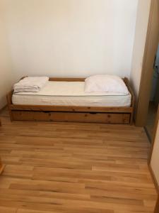 a bed in a room with a wooden floor at Ferienwohnung Brigitta in Altenbeken