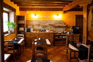 a kitchen with wooden cabinets and a brick wall at Posada La Fabula in Santillana del Mar