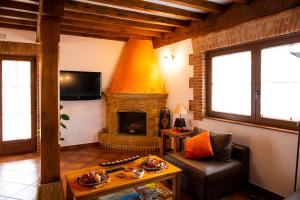 a living room with a fireplace and a couch at Posada La Fabula in Santillana del Mar