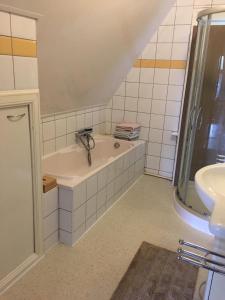 bagno con vasca e lavandino di Het Huis a Velp