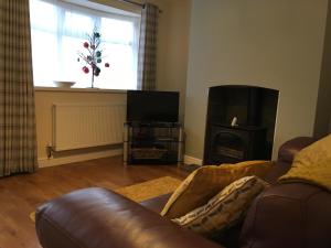 a living room with a leather couch and a fireplace at Countryside townhouse 