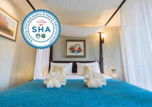 a bedroom with a blue bed with two white pillows at La Villa Boutique hotel in Aranyaprathet