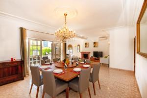 a dining room and living room with a table and chairs at Villa Morais by Algarve Vacation in Guia