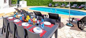 a dining table and chairs next to a swimming pool at Villa Morais by Algarve Vacation in Guia