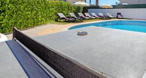 a swimming pool with chairs and a table and a pool at Villa Morais by Algarve Vacation in Guia