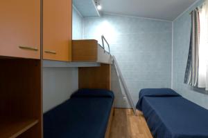 a small room with two beds and a staircase at Camping Village Tuscia Tirrenica in Tarquinia